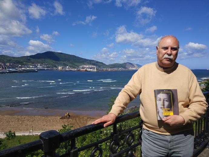 Javier Campo posa en Algorta, con la playa de Ereaga al fondo, con su nuevo libro en la mano.