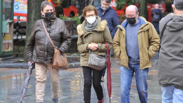 Varias personas pasean protegidas con mascarilla por la pandemia del coronavirus