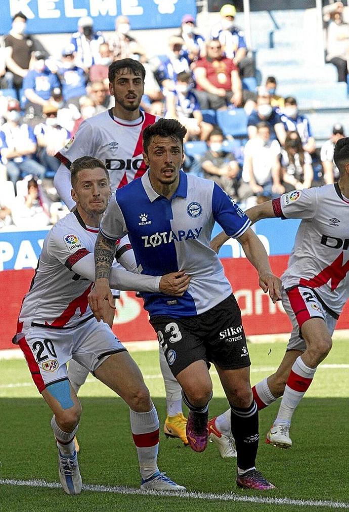 Ximo Navarro trata de rematar un balón mientras Balliu le agarra durante el Alavés-Rayo. Foto: Josu Chavarri