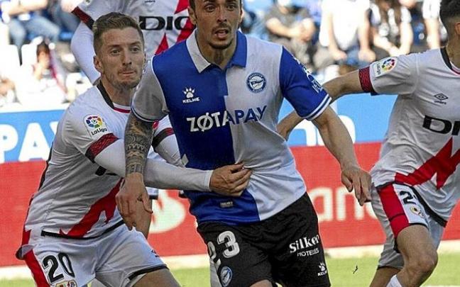 Ximo Navarro trata de rematar un balón mientras Balliu le agarra durante el Alavés-Rayo. Foto: Josu Chavarri