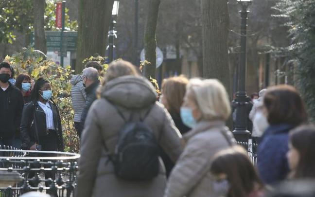 Personas andando por la calle con mascarilla.
