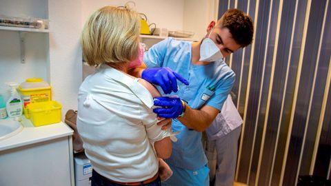Un sanitario administra una vacuna de la gripe a una mujer