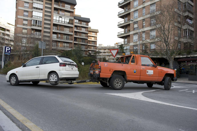 Una grúa trasladando un coche al depósito municipal.