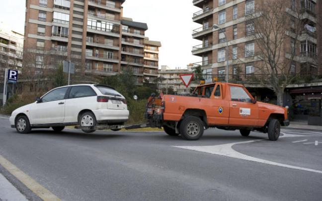 Una grúa trasladando un coche al depósito municipal.
