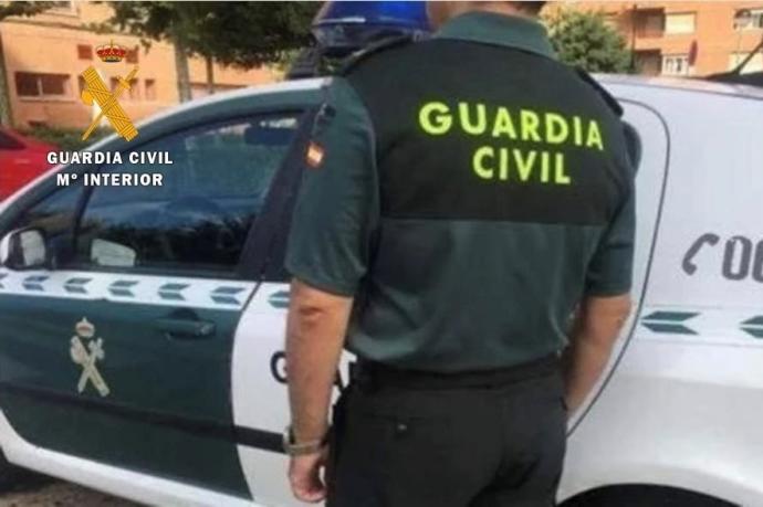 Un agente junto a su vehículo de la Guardia Civil.