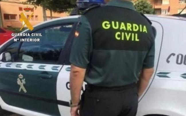 Un agente junto a su vehículo de la Guardia Civil.