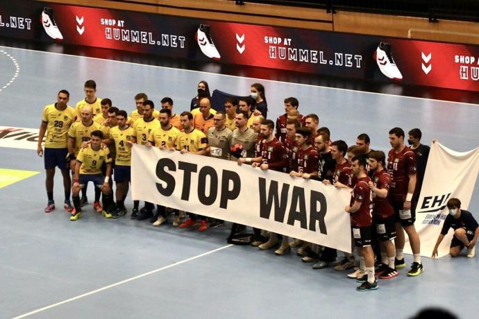 Ambos equipos posaron con una pancarta con el lema 'Stop war' (no a la guerra).