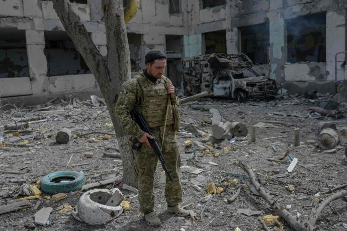 Un soldado ucraniano junto a los restos de una escuela bombardeada en Jersón.