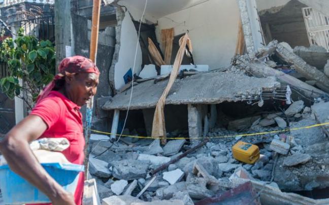 Una mujer pasa por delante de una casa destruida por el terremoto. Una mujer pasa por delante de una casa destruida por el terremoto.