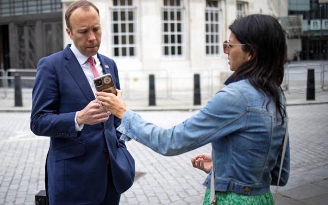 El secretario de Salud de Reino Unido, Matt Hancock mirando la pantalla del teléfono de su ayudante y amante, Gina Coladangelo.