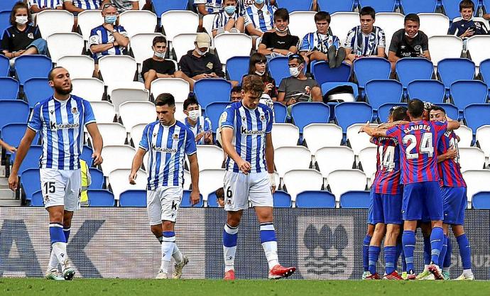 Las caras de resignación de Blasco, Alkain y Urko contrastan con la alegría de los los jugadores del Eibar, que, de fondo, celebran uno de los goles anotados en la tarde de ayer en Anoeta.