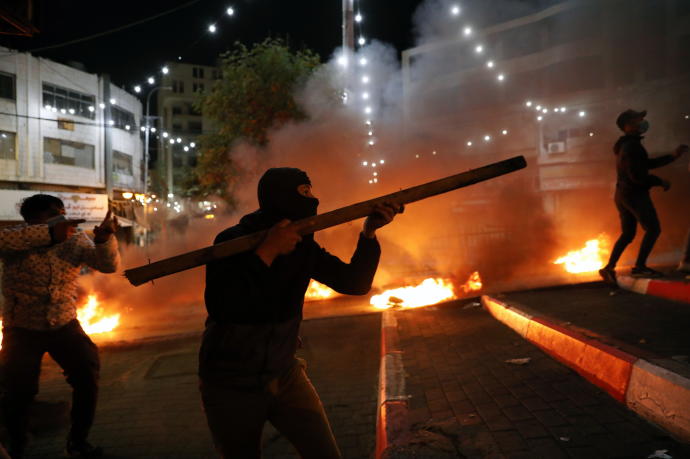 Manifestantes palestinos enfrentándose a fuerzas israelíes en Hebrón en protesta por las últimas muertes de palestinos