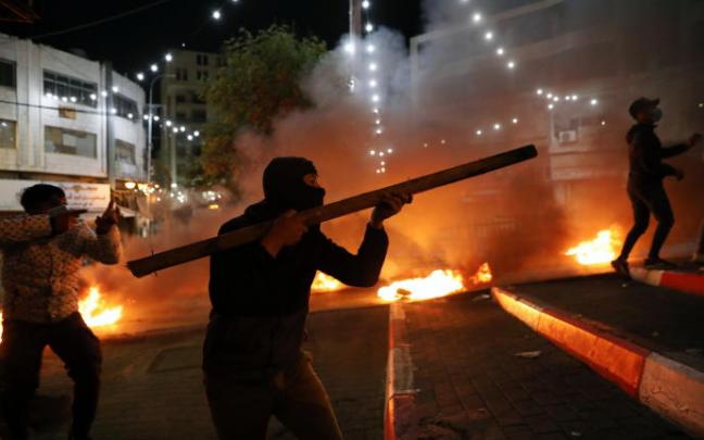 Manifestantes palestinos enfrentándose a fuerzas israelíes en Hebrón en protesta por las últimas muertes de palestinos Manifestantes palestinos enfrentándose a fuerzas israelíes en Hebrón en protesta por las últimas muertes de palestinos