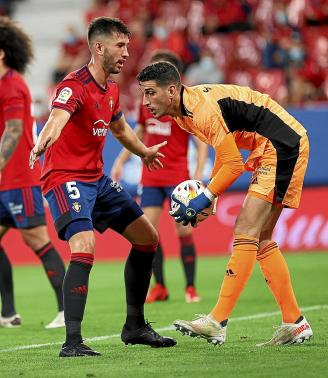 Sergio Herrera atrapa el balón con la protección de David García durante el Osasuna-Celta de la segunda jornada disputado en El Sadar.