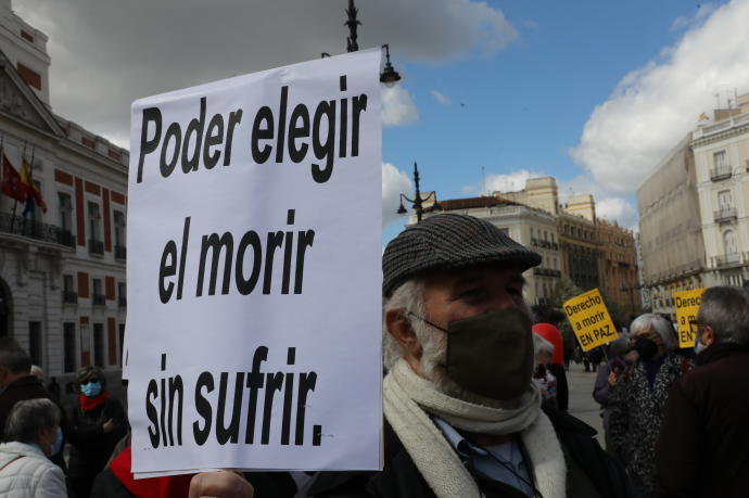 Un hombre con un cartel durante una concentración de Derecho a Morir Dignamente en la Puerta del Sol, en Madrid. (Foto de archivo)