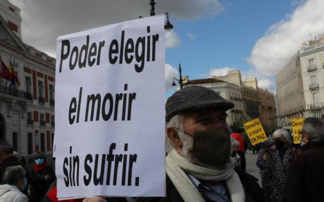 Un hombre con un cartel durante una concentración de Derecho a Morir Dignamente en la Puerta del Sol, en Madrid. (Foto de archivo)