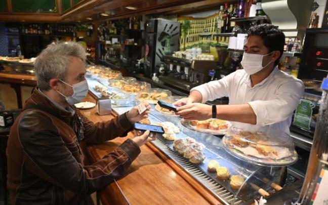 Un cliente muestra su pasaporte covid al responsable de un local hostelero en Bilbao. Un cliente muestra su pasaporte covid al responsable de un local hostelero en Bilbao.