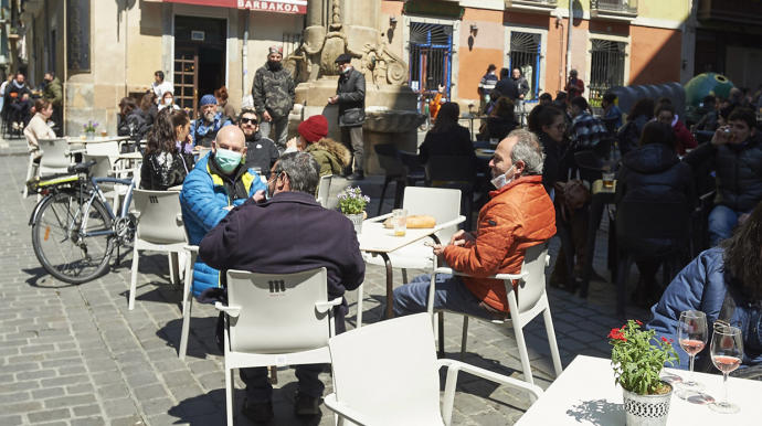 Varios grupos de personas sentadas en las terrazas situadas en la Calle Navarrería de Pamplona.