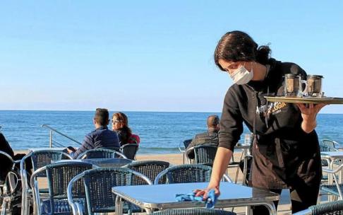 Una camarera del bar Xarabi de Zarautz limpia la mesa después de recogerla.