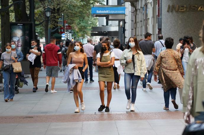 Varias personas pasean protegidas con mascarillas por la pandemia de coronavirus