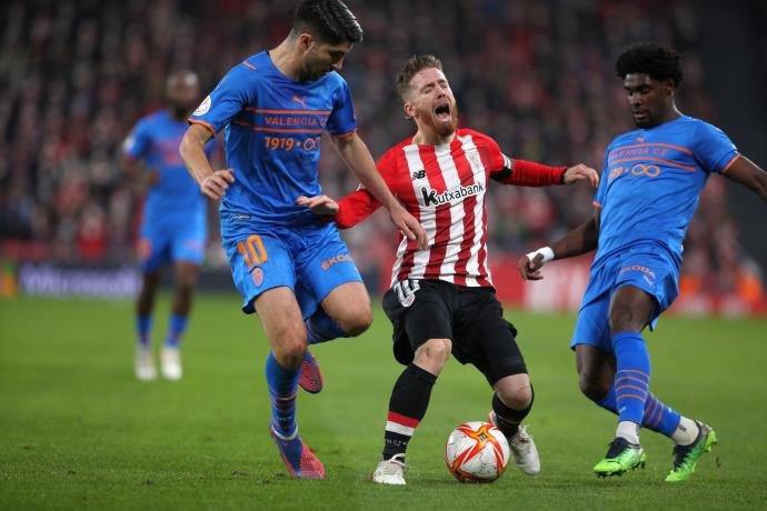 Iker Muniain es presionado por dos rivales del Valencia en el partido de ida.