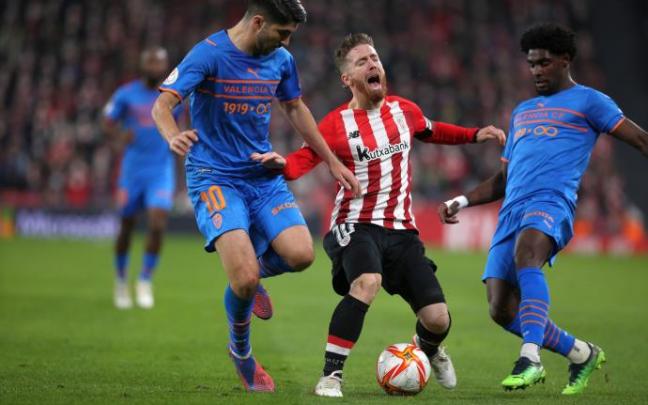 Iker Muniain es presionado por dos rivales del Valencia en el partido de ida.