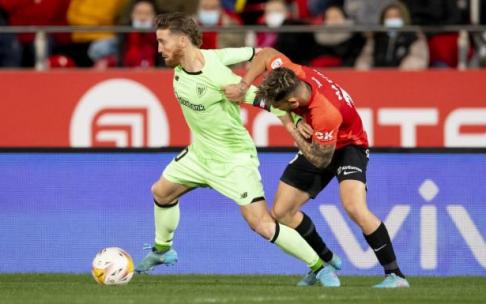 Iker Muniain protege el balón ante Pablo Maffeo, que le agarra ostensiblemente.