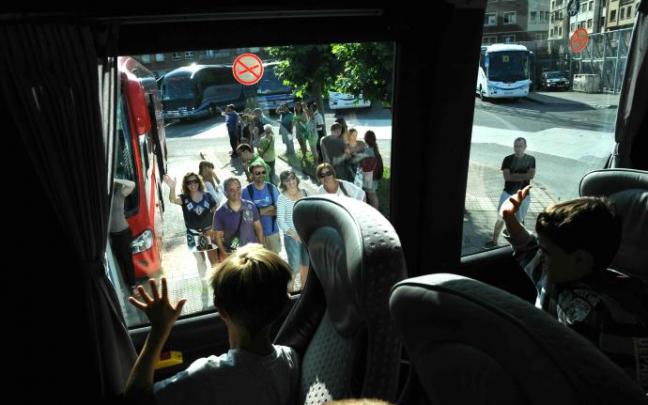 Niños se despiden de sus padres en el autobús.
