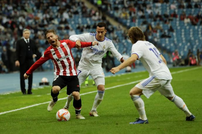 Iker Muniain se queja de una falta de Lucas Vázquez ante la mirada de Modric.