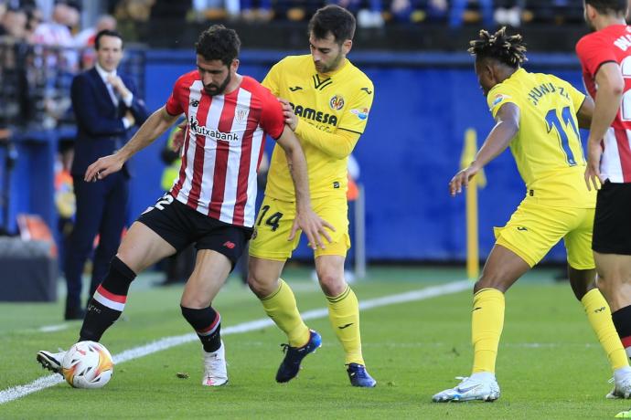 Raúl García protege un balón ante la presión de Manu Trigueros.