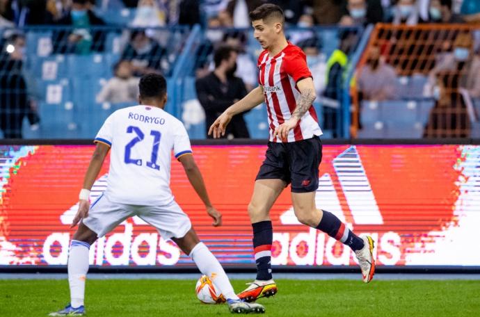 Oihan Sancet conduce un balón ante la presión de Rodrygo.