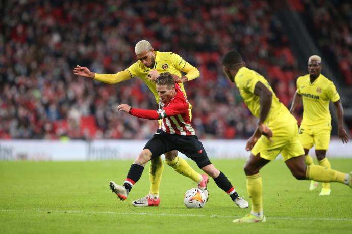 Iker Muniain protege un balón ante Aurier y Estupiñán.