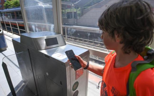 Un usuario consulta su teléfono móvil junto a una de las canceladoras de la red de Metro Bilbao, que permitirán el abono de viajes con estos terminales. Un usuario consulta su teléfono móvil junto a una de las canceladoras de la red de Metro Bilbao, que permitirán el abono de viajes con estos terminales.