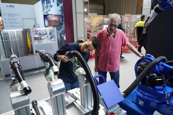 Dos asistentes observan una de las máquinas expuestas en la Bienal.