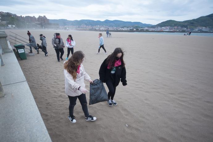 Dos alumnas, con una bolsa para recoger basura.