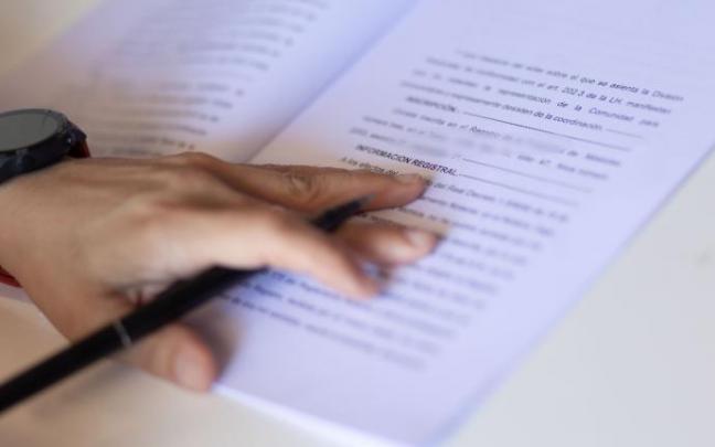 Una mujer con un bolígrafo señala una escritura de compraventa de una hipoteca.