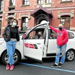 Miriam Macías, Begoña Valverde y Julen del Arco posan con un taxi a las puertas del Pabellón Revilla del hospital de Basurto, donde ingresan pacientes con covid.