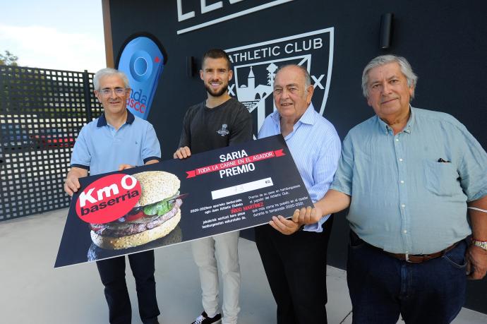 Iñigo Martínez recibe de manos de Baserria Km 0 su peso en hamburguesas.