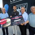 Iñigo Martínez recibe de manos de Baserria Km 0 su peso en hamburguesas.