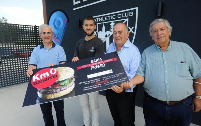 Iñigo Martínez recibe de manos de Baserria Km 0 su peso en hamburguesas.