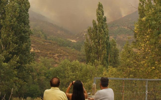 Tres vecinos observan el incendio de Navalacruz (Ávila), que ha arrasado casi 22.000 hectáreas. Tres vecinos observan el incendio de Navalacruz (Ávila), que ha arrasado casi 22.000 hectáreas.