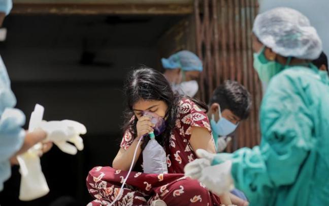 Una niña india recibe oxígeno a la puerta de un hospital Una niña india recibe oxígeno a la puerta de un hospital