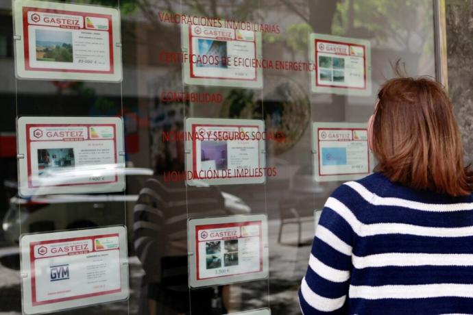 Una mujer observa el escaparate de una inmobiliaria de Vitoria