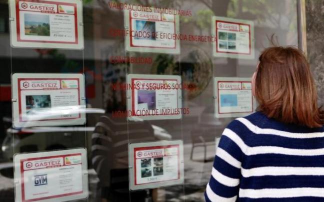Una mujer observa el escaparate de una inmobiliaria de Vitoria