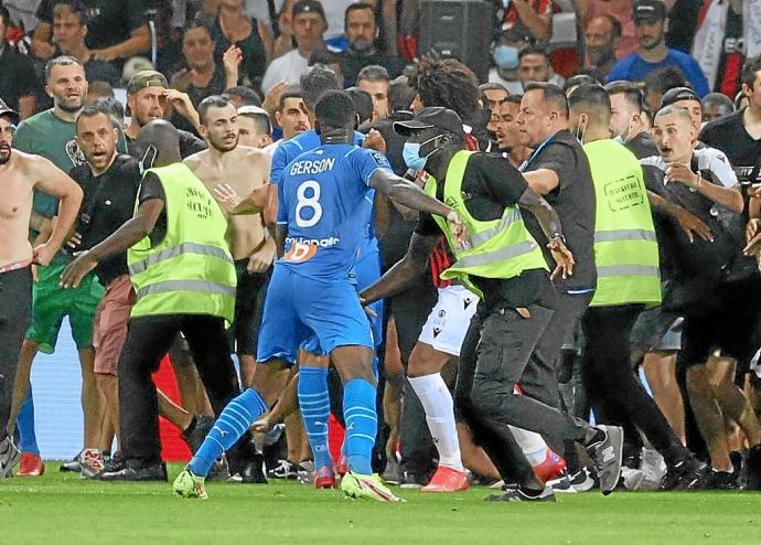 La seguridad del Niza trata de detener a los ultras, que persiguen a jugadores del Marsella. Foto: Afp