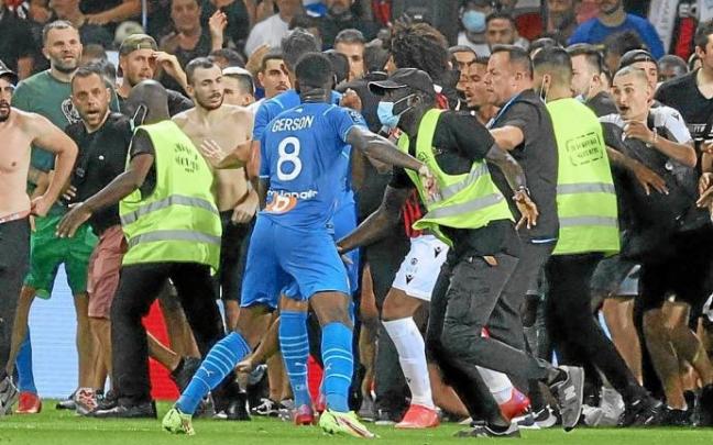 La seguridad del Niza trata de detener a los ultras, que persiguen a jugadores del Marsella. Foto: Afp