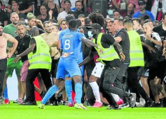 La seguridad del Niza trata de detener a los ultras, que persiguen a jugadores del Marsella. Foto: Afp
