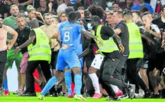 La seguridad del Niza trata de detener a los ultras, que persiguen a jugadores del Marsella. Foto: Afp