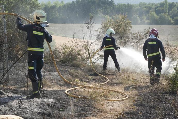 Bomberos forales apagan los rescoldos de un incendio forestal.