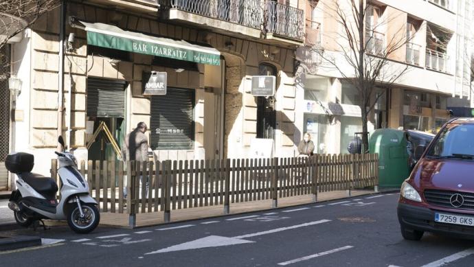 Una terraza colocada en una zona de aparcamiento.